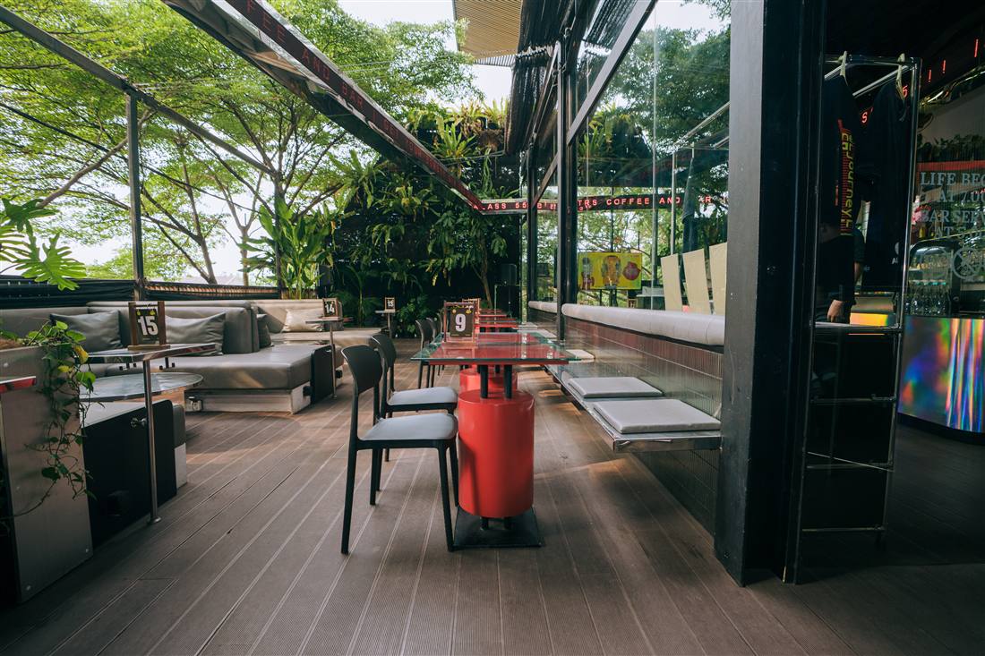 Terrace lounge seating with red tables and plants at ALTRS