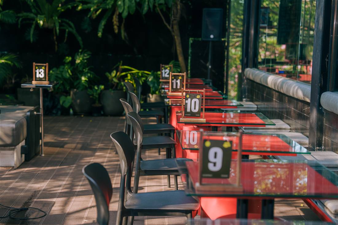 Row of numbered tables along the glass terrace at ALTRS