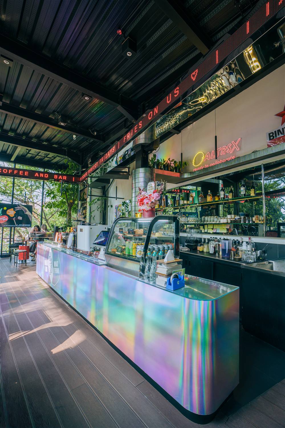 ALTRS bar counter lined with bottles and glassware under neon lights
